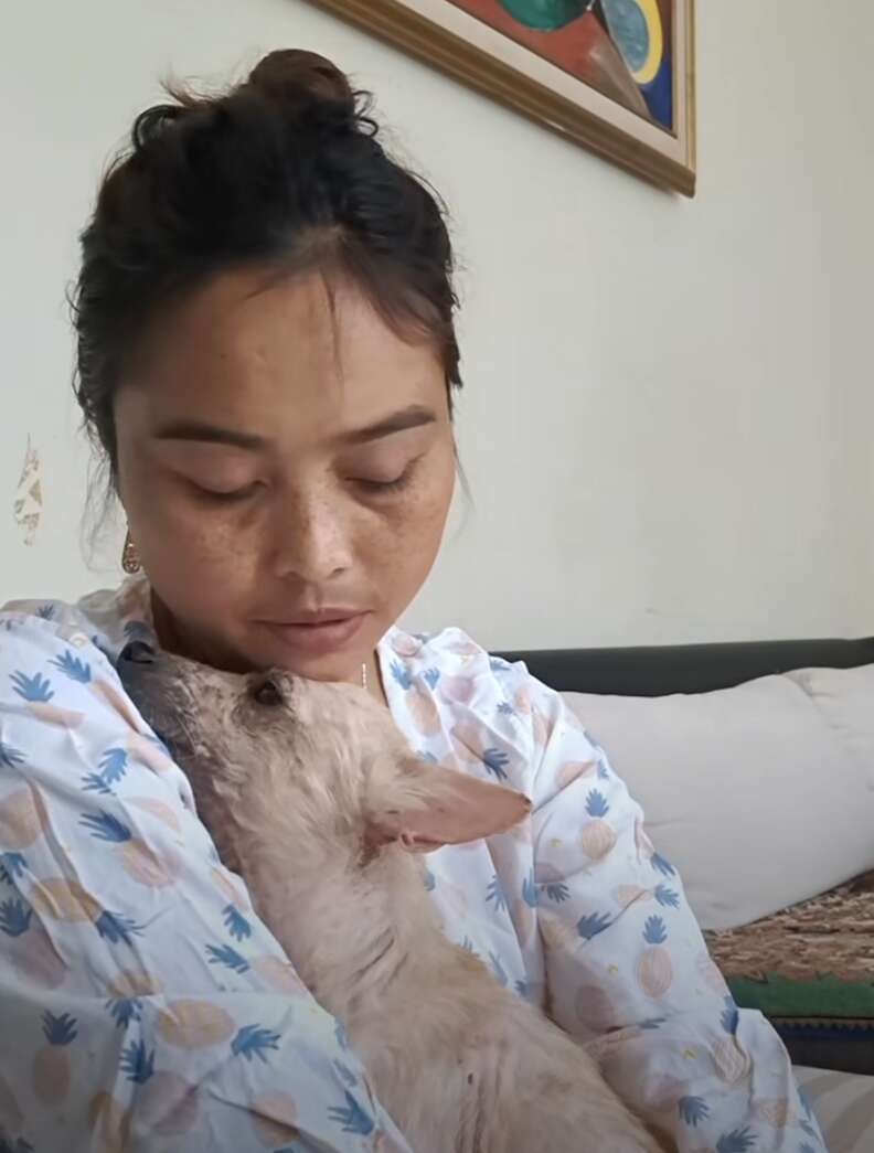 Woman holding dog in arms